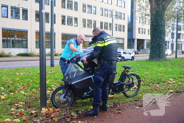 Persoon op bakfiets glijdt onderuit door bladeren op fietspad