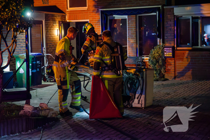 Brandweer blust brandende wasmachine