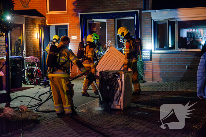 Brandweer blust brandende wasmachine