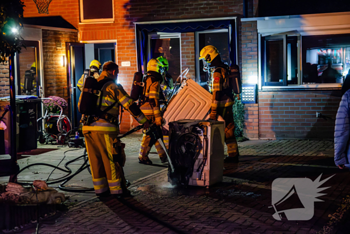 Brandweer blust brandende wasmachine