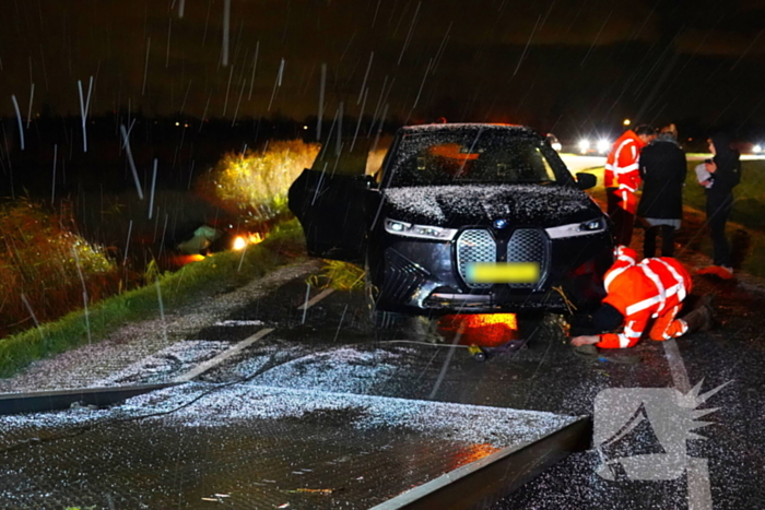 Twee auto's te water in bocht op gladde dijk