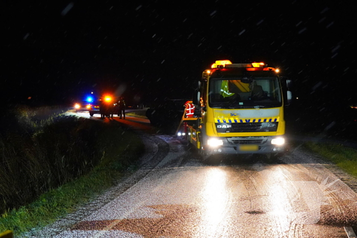 Twee auto's te water in bocht op gladde dijk