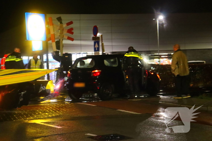 Auto belandt gedeeltelijk op spoor bij overweg