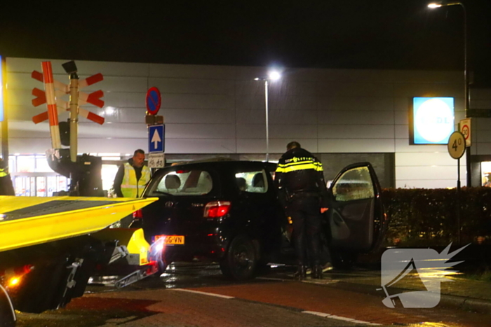 Auto belandt gedeeltelijk op spoor bij overweg