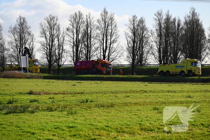 Vrachtwagen komt vast te zitten in weiland