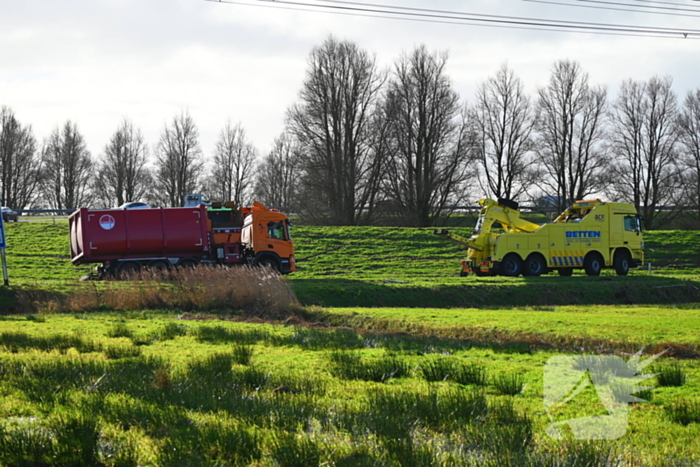 Vrachtwagen komt vast te zitten in weiland