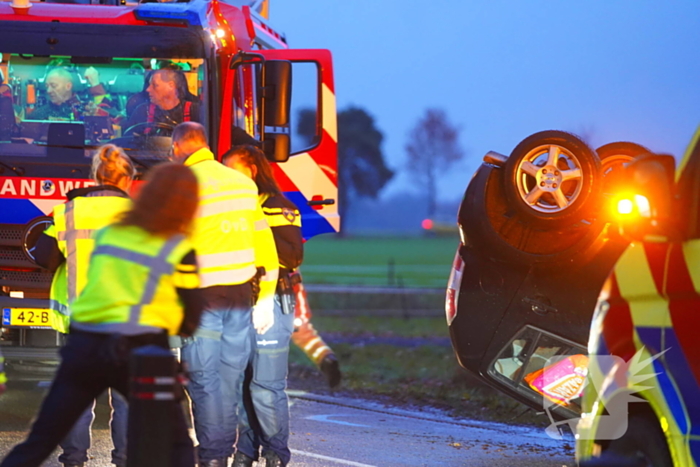 Auto op de kop na botsing met trekker en boom