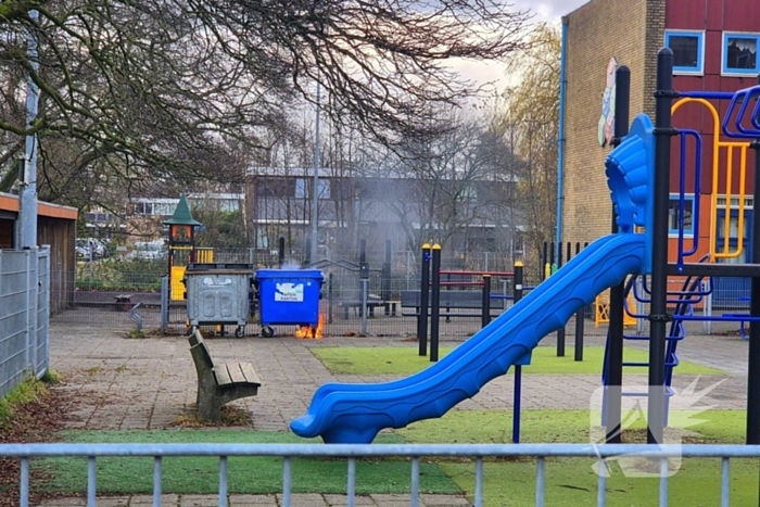 Papiercontainer op schoolplein in brand