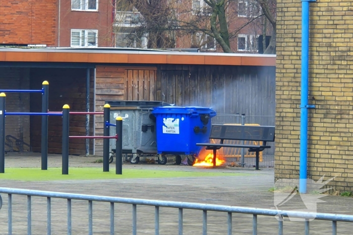 Papiercontainer op schoolplein in brand