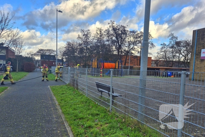 Papiercontainer op schoolplein in brand