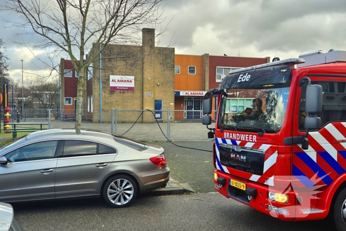 Papiercontainer op schoolplein in brand