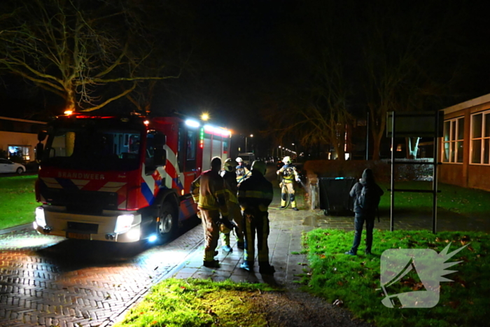 Brandweer blust brand in vuilcontainer