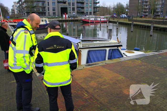 Boot verdwijnt onder water in haven, berging trekt veel bekijks