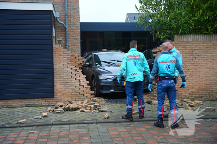 Auto rijdt dwars door tuinmuur