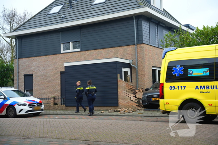 Auto rijdt dwars door tuinmuur