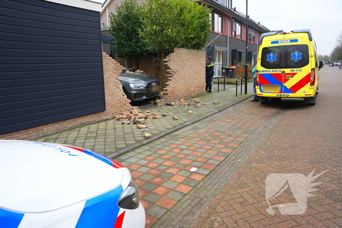 Auto rijdt dwars door tuinmuur