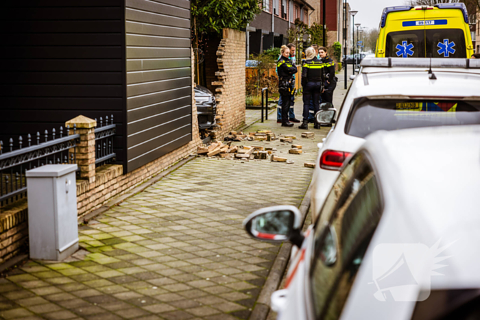 Auto rijdt dwars door tuinmuur