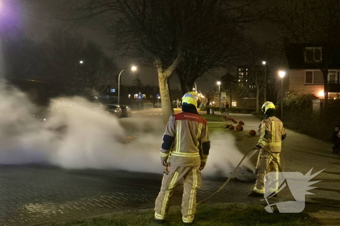 Brandweer blust afvalbrand op straat