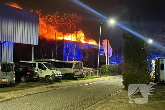 Vlammen slaan uit dak van gebouw