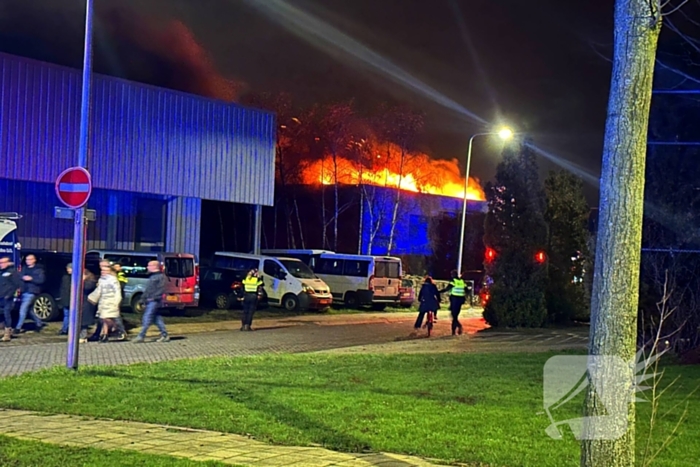 Vlammen slaan uit dak van gebouw