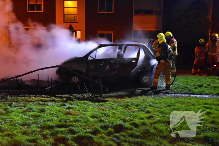 Auto in brand gestoken op grasveld