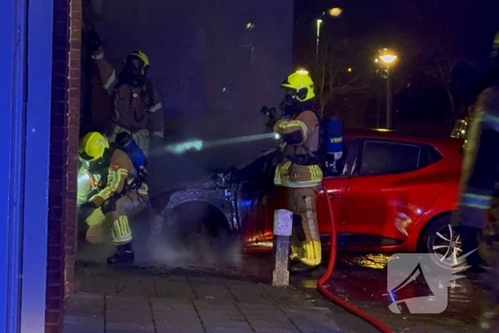 Auto brandt uit tegen gevel van flatgebouw